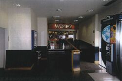 A long, dark corridor with the entrance to a Wimpy restaurant at the end of it.