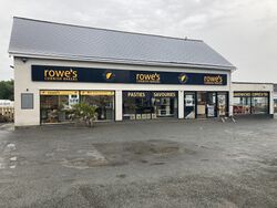 A shop building with a sign saying Rowe's Cornish Bakers, pasties, savouries, sandwiches, coffee & tea.