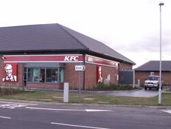 Side of a building with a KFC-branded drive thru window.