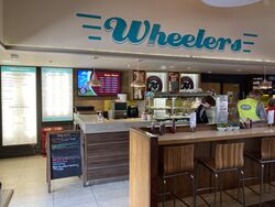 A restaurant counter with Wheelers painted on the wall.
