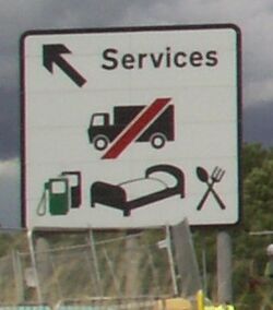 A sign saying Services, followed by a picture of a HGV with a red line through it.