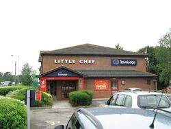 The end of a brick building, with Little Chef and Travelodge logos attached to it.
