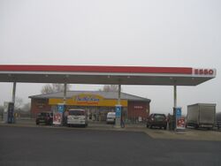 An Esso forecourt with an On The Run shop in the distance.