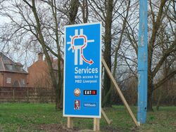 A cardboard road sign saying: Services with access to M62 Liverpool.